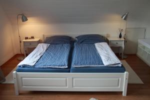 ein Schlafzimmer mit zwei Betten und zwei Nachttischen in der Unterkunft Ferienwohnung weißes Haus in Meeschendorf
