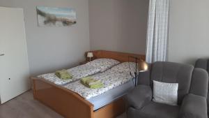 ein kleines Schlafzimmer mit einem Bett und einem Stuhl in der Unterkunft Ferienwohnung Schattschneider in Burgtiefe auf Fehmarn 