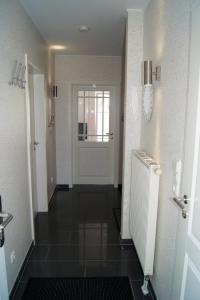 a hallway with a white door and a black tile floor at Feriendoppelhaushälfte Böttcher in Meeschendorf