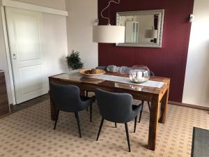 a dining room table with chairs and a mirror at Feriendoppelhaushälfte Böttcher in Meeschendorf