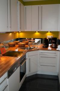 a kitchen with white cabinets and wooden counter tops at Feriendoppelhaushälfte Böttcher in Meeschendorf +17 photos