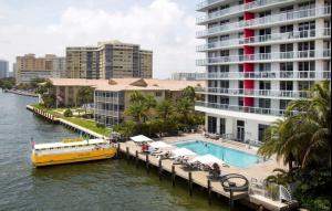 a yellow boat on a river next to a large building at Apt Miami Beach 1B1B with Kitchen Beach and Mall 2308 in Hallandale Beach