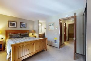 a bedroom with a large wooden bed and a hallway at Woodlands 34 in Mammoth Lakes +99 photos