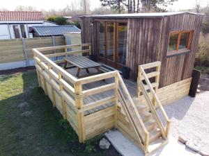 a large wooden cabin with a wooden staircase in a yard at La Tiny House in Ardres +12 photos