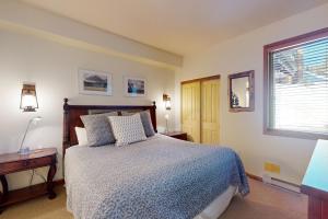 Un dormitorio con una cama y una mesa y una ventana. en Eagle Run 107, en Mammoth Lakes