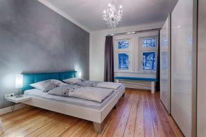 une chambre avec un grand lit et un lustre dans l'établissement "Villa Anker" 1 Etage - rechts, à Fehmarn