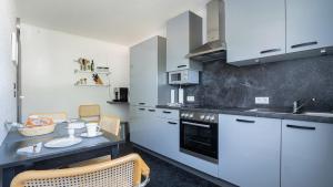 Una cocina con gabinetes blancos y una mesa y sillas. en Haus Westwind Nr1, en Schlagsdorf