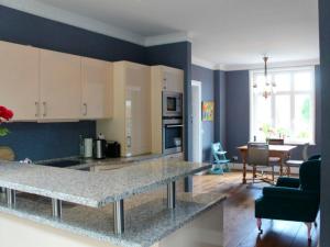 a kitchen with a counter top and a living room at Villa Pura Vida in Fehmarn +16 photos