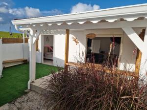 a white pergola on a house with green grass at Appartement au centre de Gosier 7 in Le Gosier