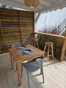 a wooden table and chairs on a patio at Appartement au centre de Gosier 7 in Le Gosier