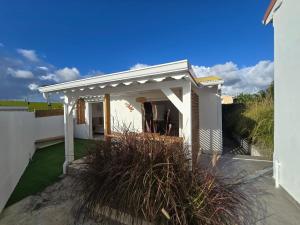a white pergola on the side of a house at Appartement au centre de Gosier 7 in Le Gosier +10 photos