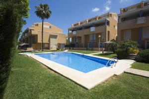 a swimming pool in a yard next to a building at El Velero in El Tosalet