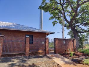 a brick house with a gate and a tree at Casa Catalina Obligado in Obligado
