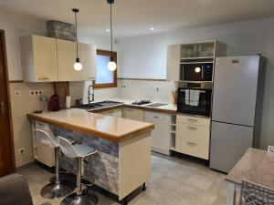 a kitchen with a white refrigerator and a counter at Maison village in Sérignan