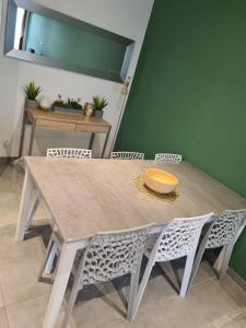 a dining room table with chairs and a green wall at Maison village in Sérignan +3 photos