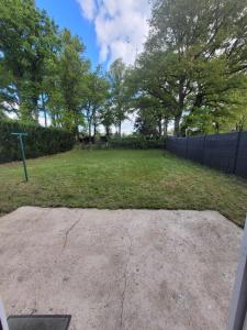 a large yard with a fence and trees at Maison, 5 Chambres équipées, tout confort , fibre in Ouzouer-sur-Loire