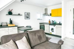 a living room with a couch and a kitchen at Charmantes Apartment mit Tiefgarage in Magdeburg