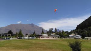 a person is flying a kite in a field at Bella Vista Queenstown in Queenstown
