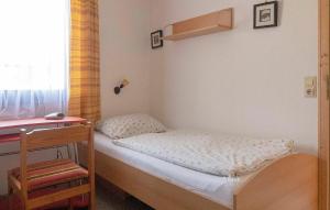 une petite chambre avec un lit et un bureau dans l'établissement Ferienhaus Nr 76, Kategorie Economy, Feriendorf Hochbergle, Allgäu, à Bichel