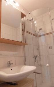 une salle de bain avec lavabo et douche dans l'établissement Ferienhaus Nr 76, Kategorie Economy, Feriendorf Hochbergle, Allgäu, à Bichel