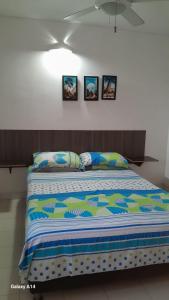 a bed in a room with three pictures on the wall at Lindo en el rodadero in Gaira +7 photos