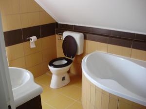 ein Badezimmer mit Toilette und Badewanne in der Unterkunft Szatmári Vendégház in Balatonlelle