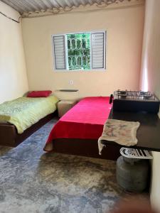 a bedroom with two beds and a window at Toca do sonic in CÃ¡ssia