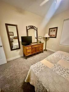 een slaapkamer met een bed en een dressoir met een spiegel bij Heron Lake in Orlando
