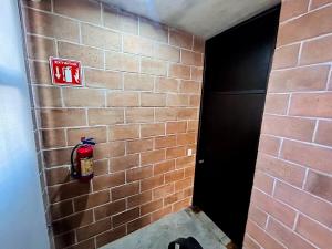 a brick wall with a fire extinguisher on it at Vistas Increíbles frente al mar by G P S rentas in Mazatlán