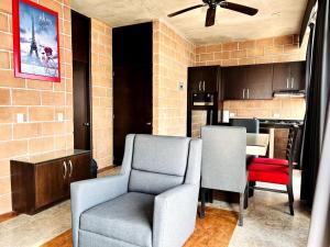 a living room with two chairs and a kitchen at Vistas Increíbles frente al mar by G P S rentas in Mazatlán