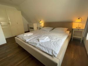 a bedroom with a bed with two towels on it at Haus am Stadtpark in Burg auf Fehmarn