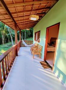 a porch of a house with a hammock on it at Chalé Céu de Minas in Visconde De Maua
