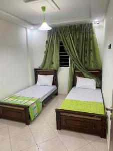 two twin beds in a room with a window at beautiful adresse " appartement vaste de luxe" in Agadir