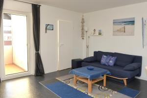a living room with a blue couch and a table at Fewo 91 WHG B 19 in Burhave in Burhave
