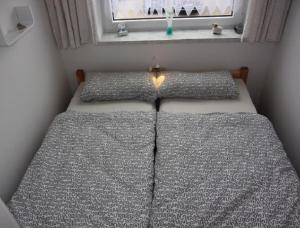 two beds in a small room with a window at Fewo 91 WHG B 19 in Burhave in Burhave +6 photos