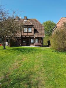 a house with a grassy yard in front of it at Ferienhaus Lichtblick am Teich in Kopendorf