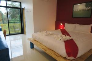 Un dormitorio con una cama con flores. en Hotel Montha en Chiang Mai