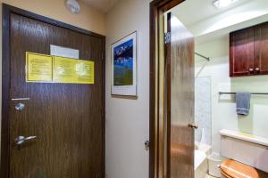 ein Badezimmer mit einer Holztür und einem WC in der Unterkunft Snowline Lodge Condo #46 - Free Wi-Fi - Sleeps 2 in Glacier