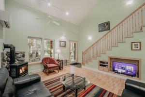 a living room with a fireplace and a staircase at Glacier Springs Cabin 12 - Wi-Fi - A-C - Evc in Glacier
