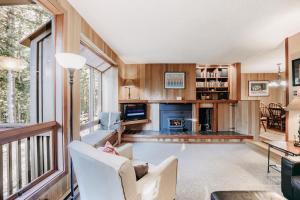 ein Wohnzimmer mit Sofa und Stühlen und einem Kamin in der Unterkunft Snowater Condo #41 - Wi-Fi - Sauna - Soaker Tub in Glacier