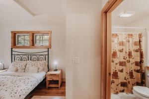 Schlafzimmer mit einem Bett, einem Fenster und einem Waschbecken in der Unterkunft Snowline Cabin #34 - Hot Tub - Wi-Fi - Ping Pong in Deming