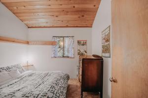 ein Schlafzimmer mit einem Bett und einer Holzdecke in der Unterkunft Snowline Cabin #43 - Hot Tub - Pets Ok - Wifi in Glacier