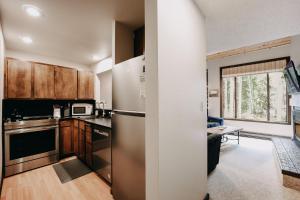 eine Küche mit Holzschränken und einem Edelstahlkühlschrank in der Unterkunft Snowater Condo #14 - Blissful Relaxation! in Glacier