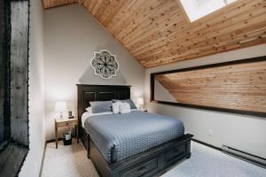 ein Schlafzimmer mit einem Bett mit Holzdecke in der Unterkunft Snowater Condo #14 - Blissful Relaxation! in Glacier + 31 Fotos