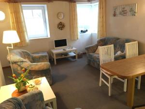 a living room with couches and a table and a television at "Uns Schün" Nr 2 in Fehmarn