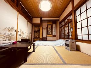 a room with a bed and a table and window at Urasa cottage at the station in Minami Uonuma