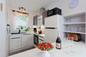 a kitchen with a bottle of wine and a bowl of fruit at Ferienhaus Teuber in Trassenheide