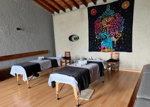 a room with four beds and a painting on the wall at Orgánico Hotel Boutique TEPOZTLÁN in Tepoztlán