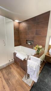a bathroom with a tub and a table with towels at Old Town Inn in San Diego