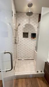 a bathroom with a shower with white tiles at Old Town Inn in San Diego